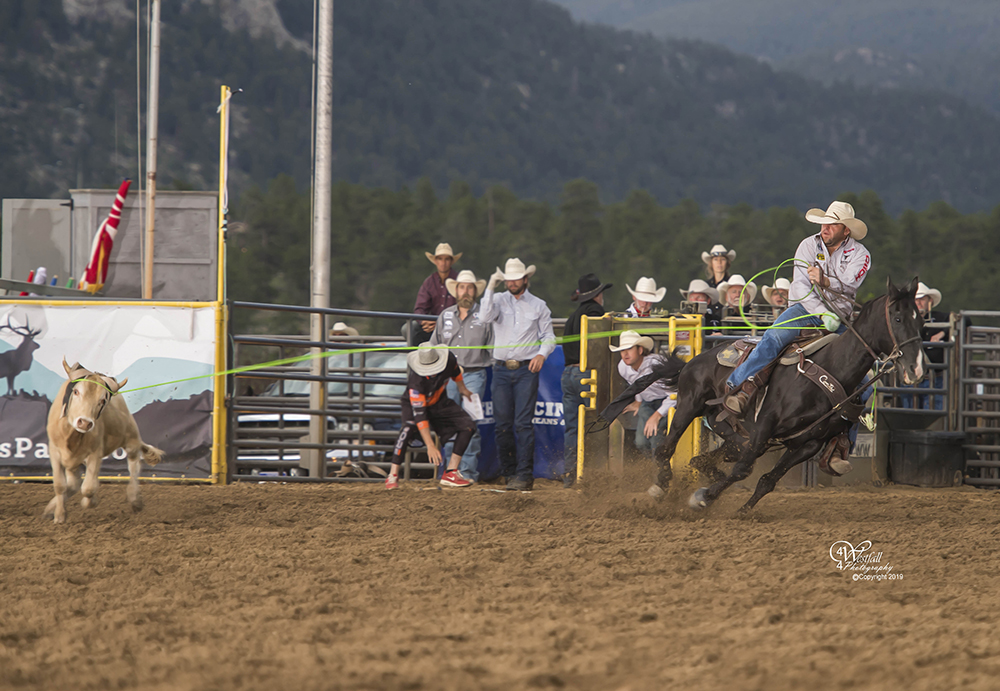 Ty Blasingame turns his steer for heeler Brandon Bates as the tandem stops the clock in 4.4 seconds to take the team roping lead at Rooftop Rodeo. (PHOTO BY GREG WESTFALL)