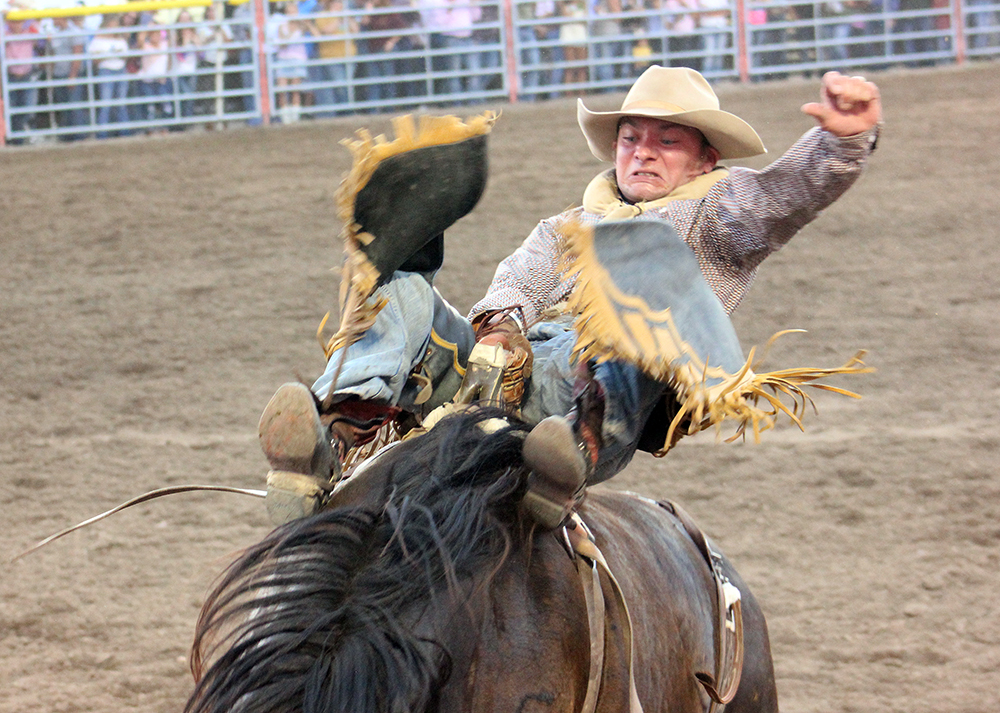 Will Lowe spurs Stace Smith's Cactus Black for 90 points Saturday night to win the first round of the Dodge City Roundup Rodeo and earn the right to compete for the championship Sunday during the championship round.