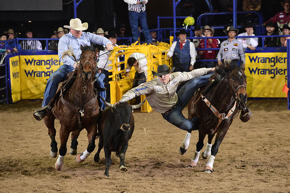 J.D. Struxness moves to his steer during his 4.3-second run Friday night to finish in a three-way tie for second place in the second round of the National Finals Rodeo. (PRCA PRORODEO PHOTO BY JAMES PHIFER)