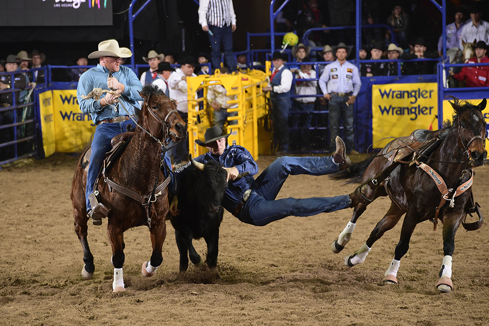 J.D. Struxness grabs ahold of his steer en route to a 4.4-second run to finish third in Thursday's eighth round of the National Finals Rodeo. (PRCA PRORODEO PHOTO BY JAMES PHIFER)