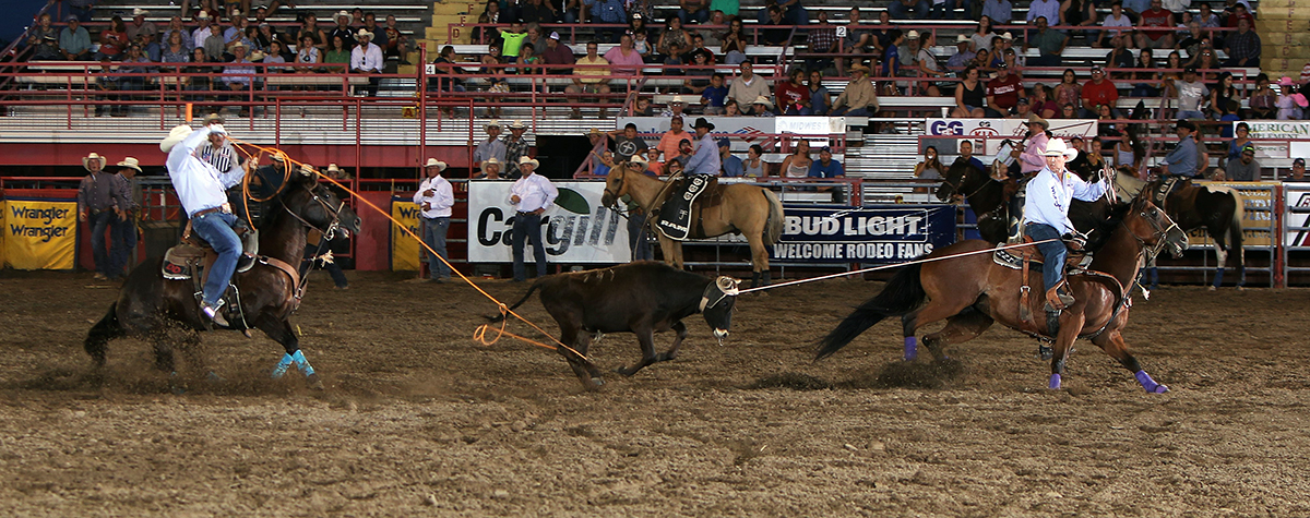 Garrett Tonozzi, right, and Dustin Davis stopped the clock in 5.7 seconds Thursday night to take the overall team roping lead at Dodge City Roundup Rodeo. (PHOTO BY DAVID SEYMORE)