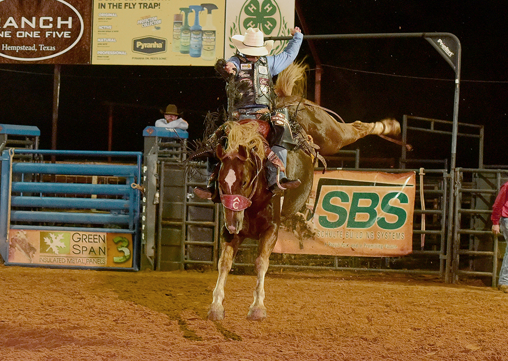 Bradley Harter rides Pete Carr Pro Rodeo's Life of Riley for 82 points Saturday night to share the saddle bronc riding victory at the Waller County Fair and Rodeo with brothers Jacobs and Sterling Crawley. (PHOTO BY DANIEL BECKENDORF)