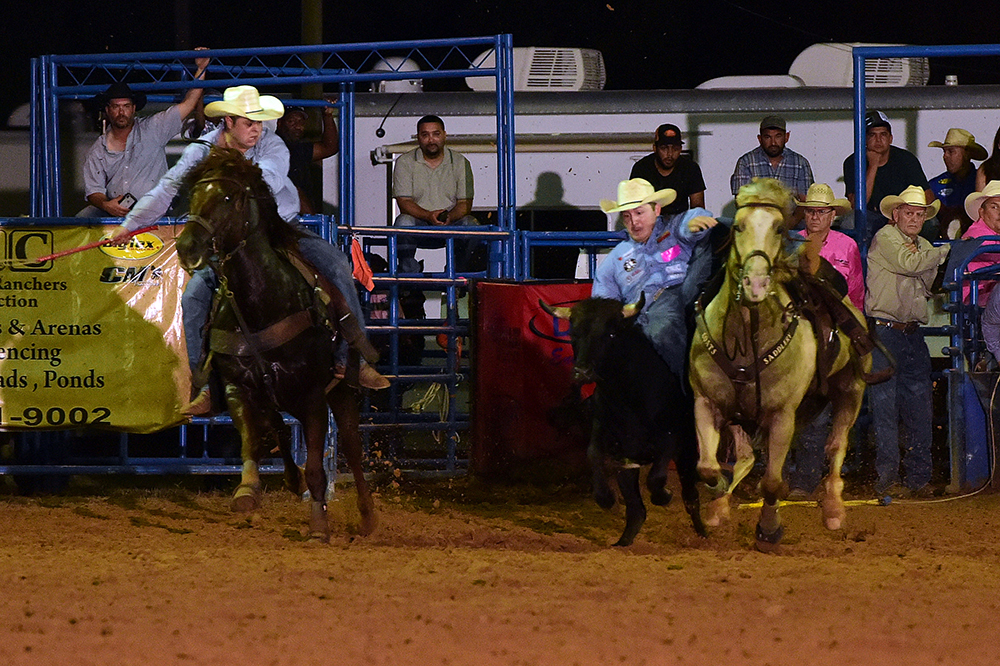 Dylan Schroeder transitions to his steer Thursday night en route a rodeo-leading, 4.2-second run. (PHOTO BY DANIEL BECKENDORF)