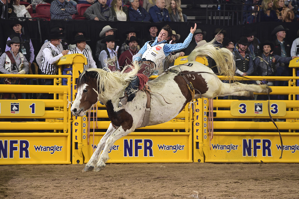 Clayton Biglow matches moves with Pickett Pro Rodeo's Freckled Bird for 88.5 points to share the sixth-round victory with two other cowboys Tuesday at the National Finals Rodeo. (PRCA PRORODEO PHOTO BY JAMES PHIFER)