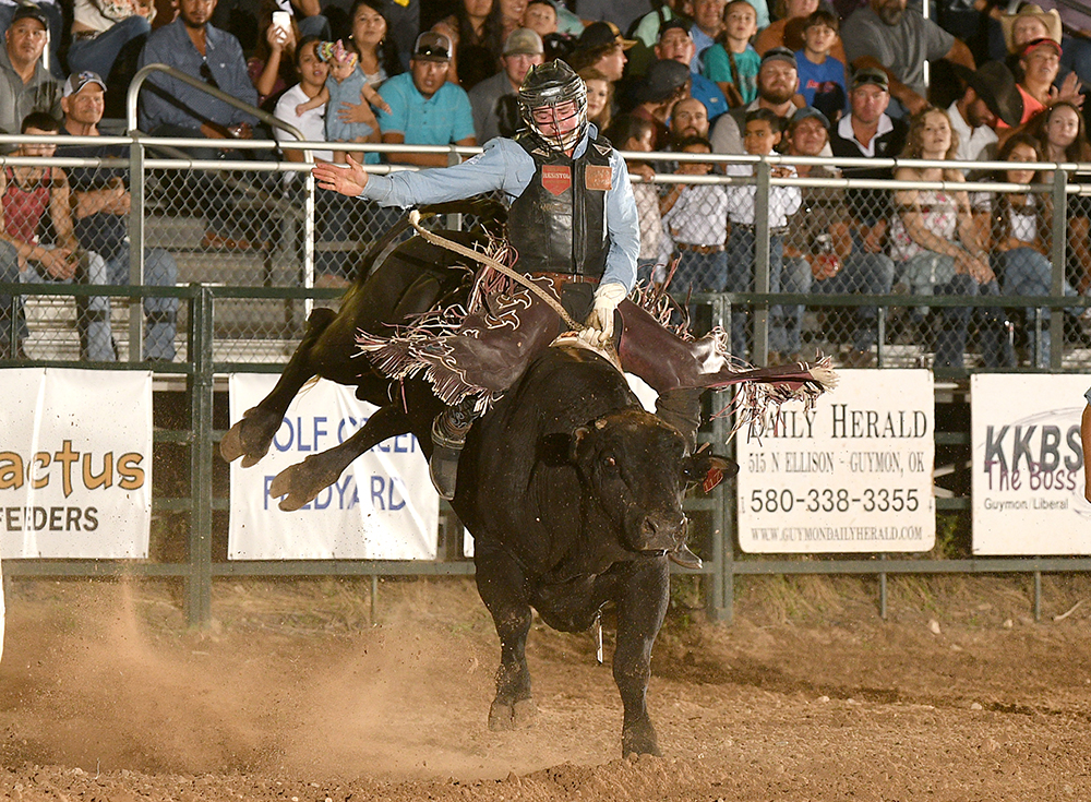 Ty Wallace rides Frontier Rodeo's Big Don for 90 points Saturday night to take the bull riding lead at the Guymon Pioneer Days Rodeo. (PHOTO BY DALE HIRSHMAN)