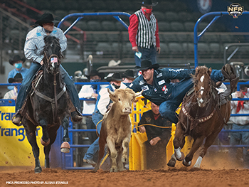Jacob Edler transitions to his steer on his way to a 3.3-second run, which earned him a share of the Round 6 victory at the National Finals Rodeo. (PRCA PRORODEO PHOTO BY ALAINA STANGLE)