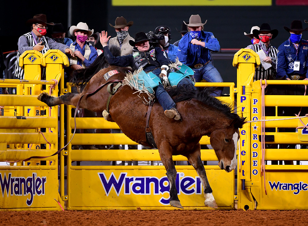Tanner Aus rides Sankey's Irish Eyes for 83.5 points to finish in a tie for third place in Wednesday's seventh round of the National Finals Rodeo. (PHOTO BY JAMES PHIFER)