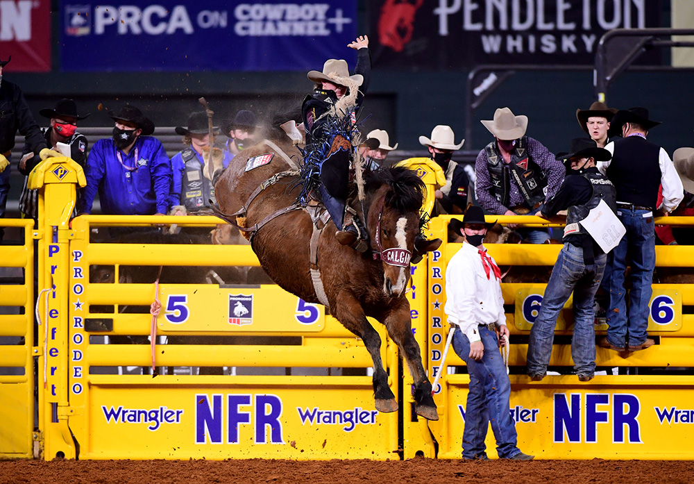 Wyatt Casper rides Calgary Stampede's Xena Warrior for 88 points to win Friday's ninth round of the National Finals Rodeo and make the race for the world title a dead heat. (PHOTO BY JAMES PHIFER)
