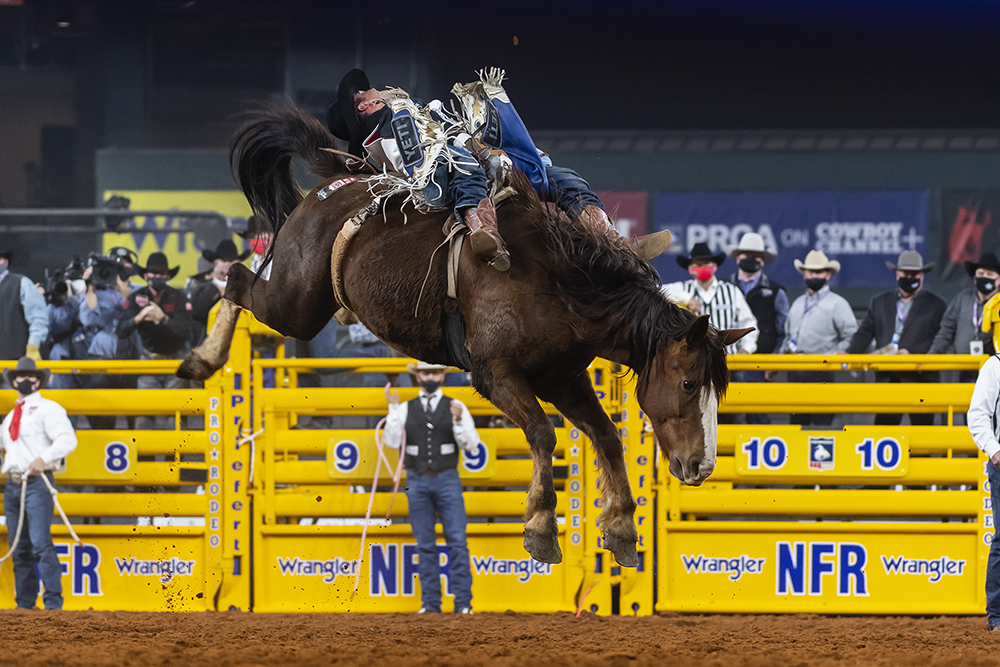 Richmond Champion spurs Beutler & Son's Killer Bee for 87.5 points to finish third in Saturday's third round of the National Finals Rodeo. (PHOTO BY JAMES PHIFER)