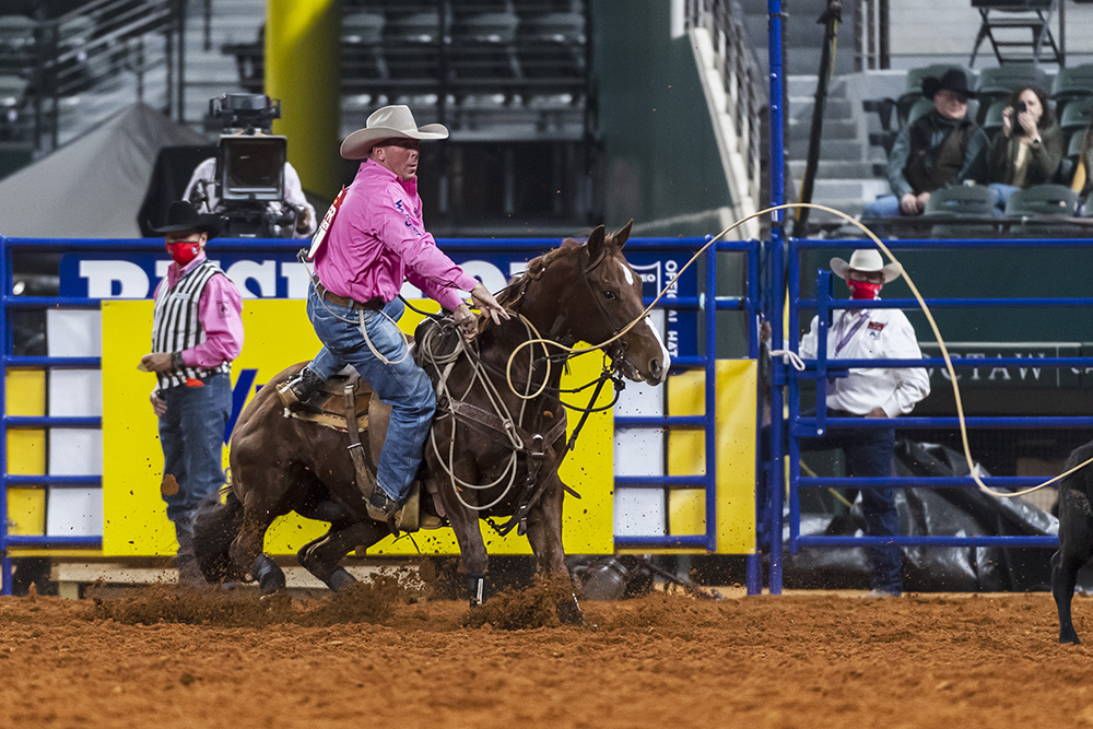 Ryan Jarrett dismounts his horse during his 8.2-second run Monday, which guided him to a third-place finish in the fifth round of the Wrangler National Finals Rodeo. (PHOTO BY JAMES PHIFER)